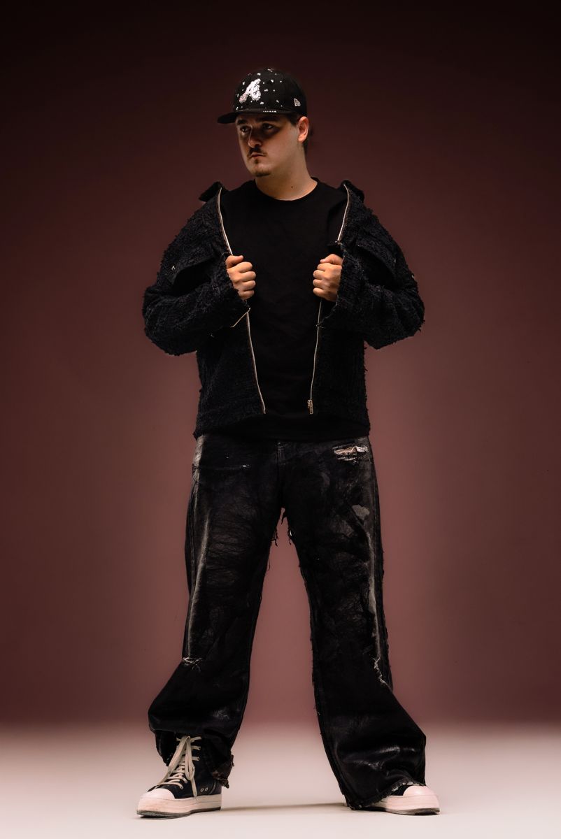 Full-length shot of ALVA DJ holding his jacket open