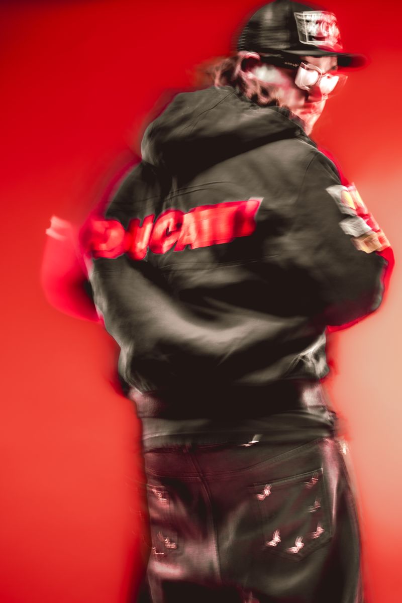 Motion-blurred back view of ALVA DJ in a racing jacket